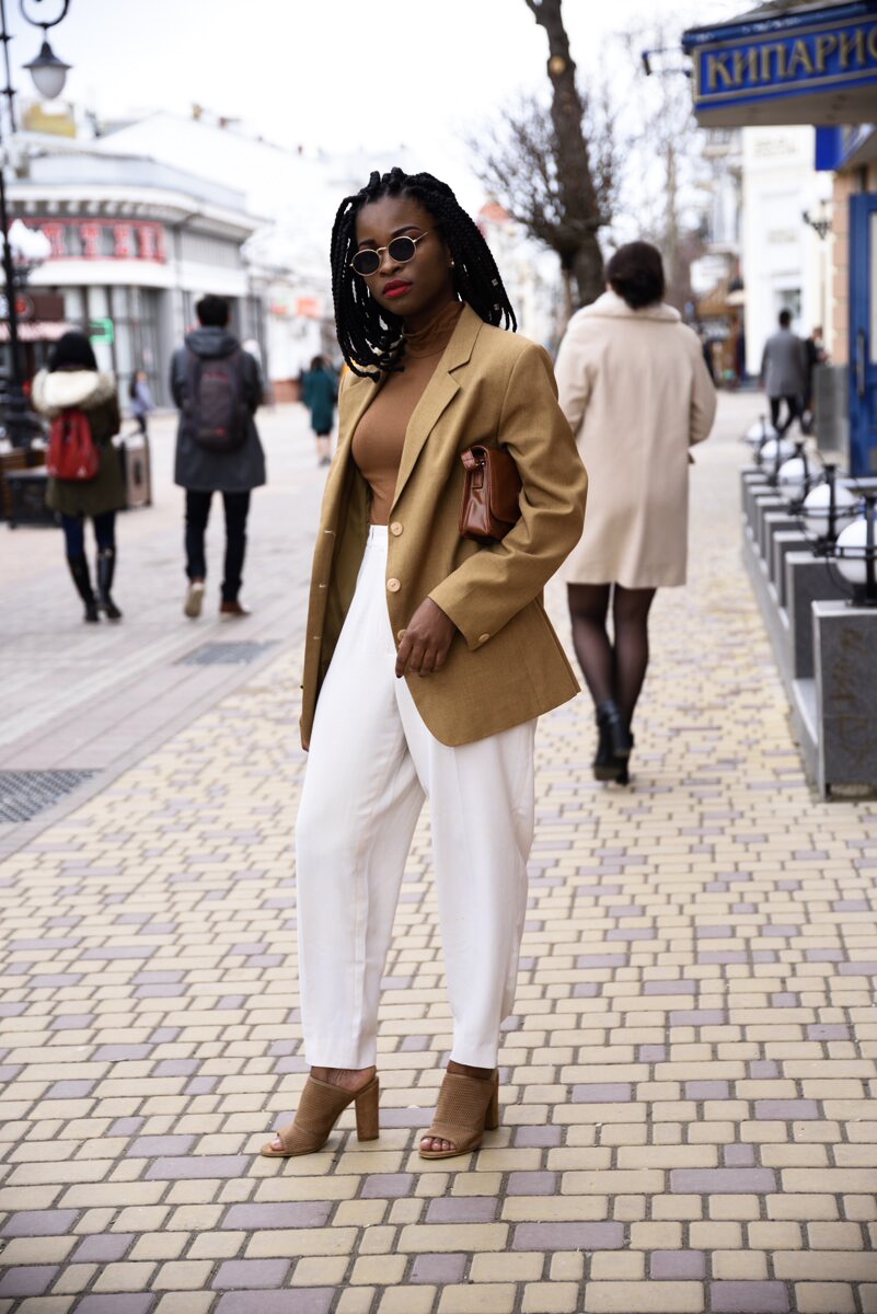 Wearing a brown blazer with turtleneck and white pants